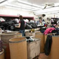 Des femmes travaillent à trier le contenu des ballots pour différents usages : guenilles, vêtements vendus dans divers magasins Frenchy's, vêtements expédiés vers d’autres pays.