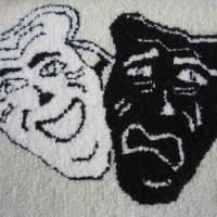  Les visages de la tragédie et de la comédie, tapis hooké de Marie-Eveline Maillet, artisane du Centre de la Mi-Carême, Grand-Étang, Cap-Breton