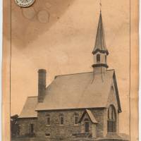 L’église souvenir avec le bouton « Soyons Acadiens » et l’image d’Évangéline, pris en 1922